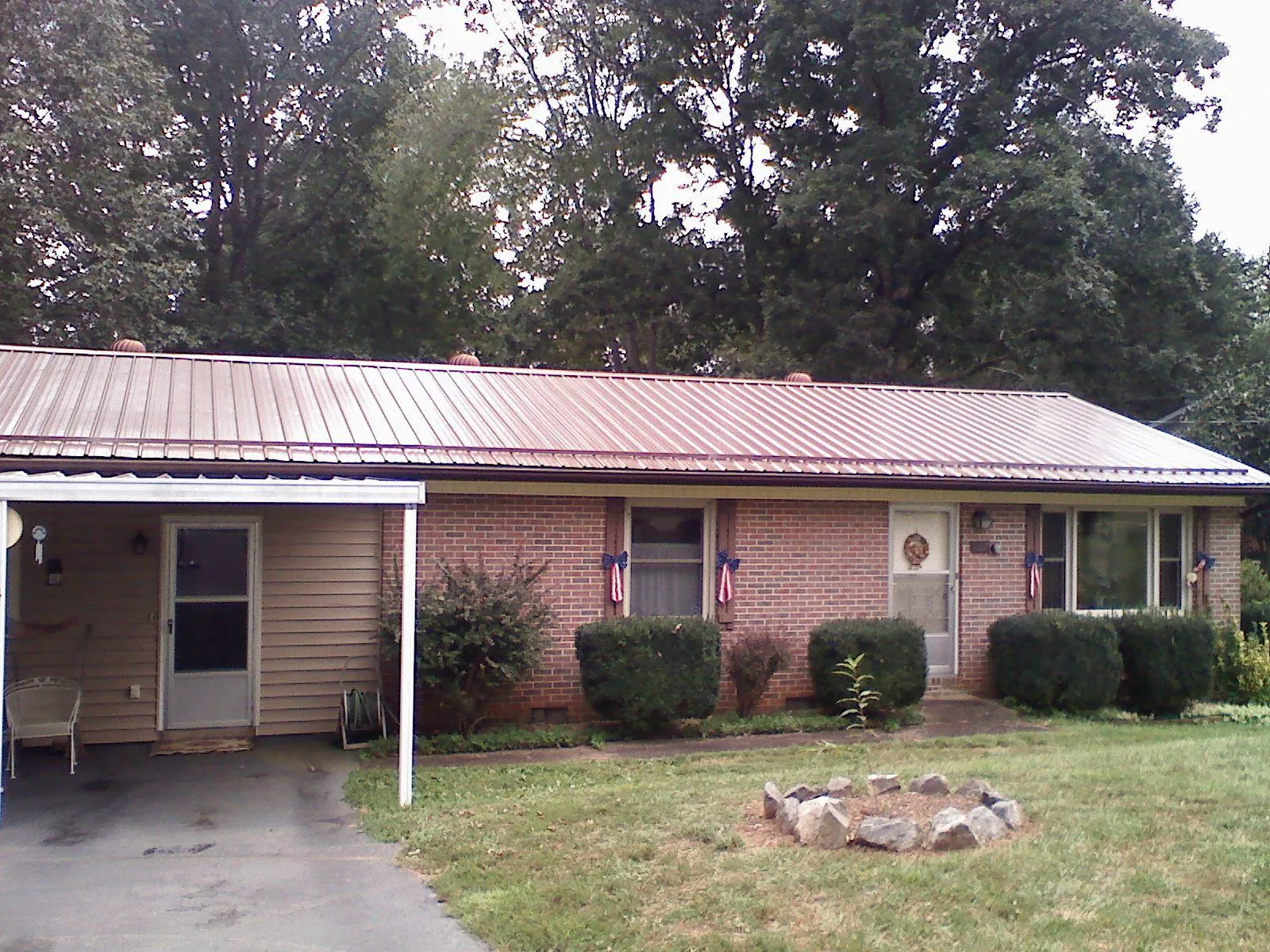 Bronze metal roof and carport on a brick ranch home — Roof Repair work by our crew in Ariel